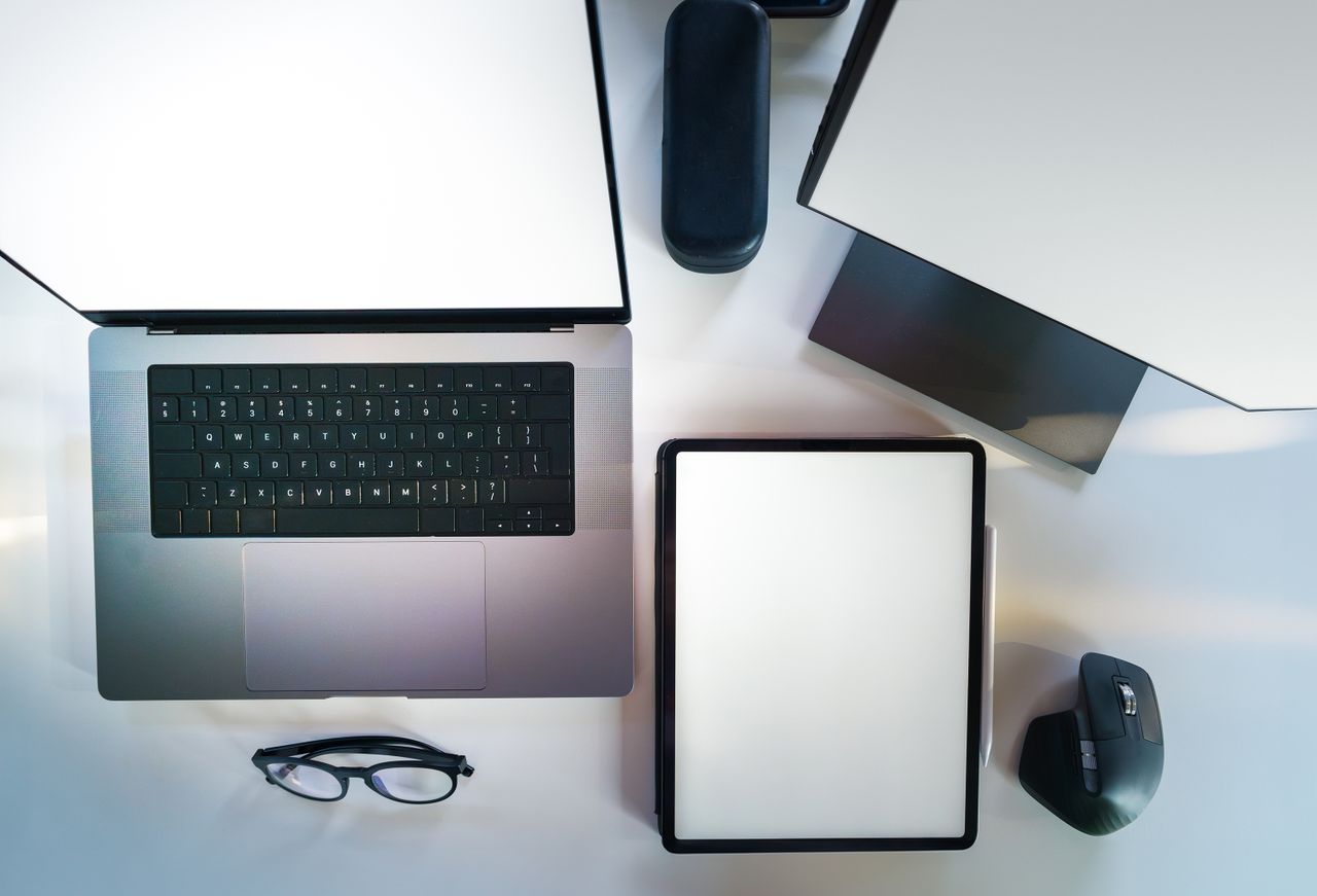 who-we-are Top view of a sleek modern office desk with a laptop, tablet, and accessories.
